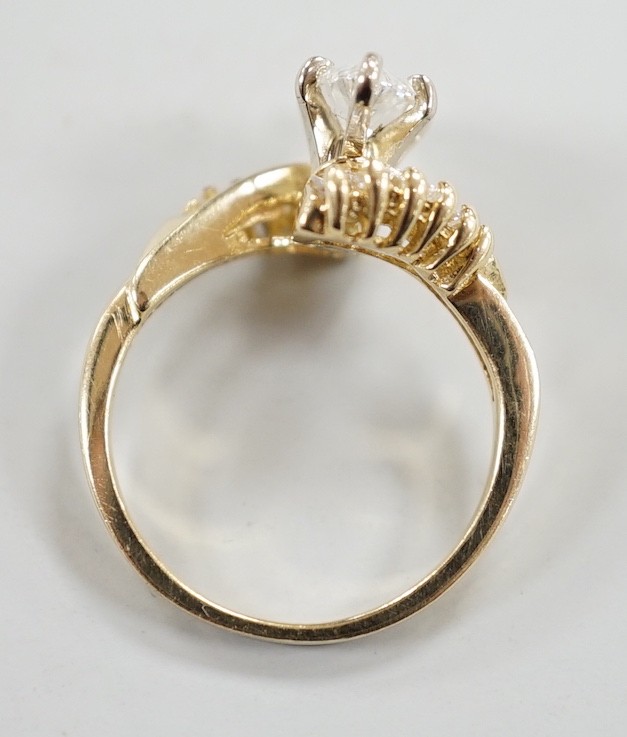 A yellow metal and singe stone marquise cut diamond set crossover dress ring, with baguette cut diamond set shoulders, size J/K, gross weight 3.2 grams.
